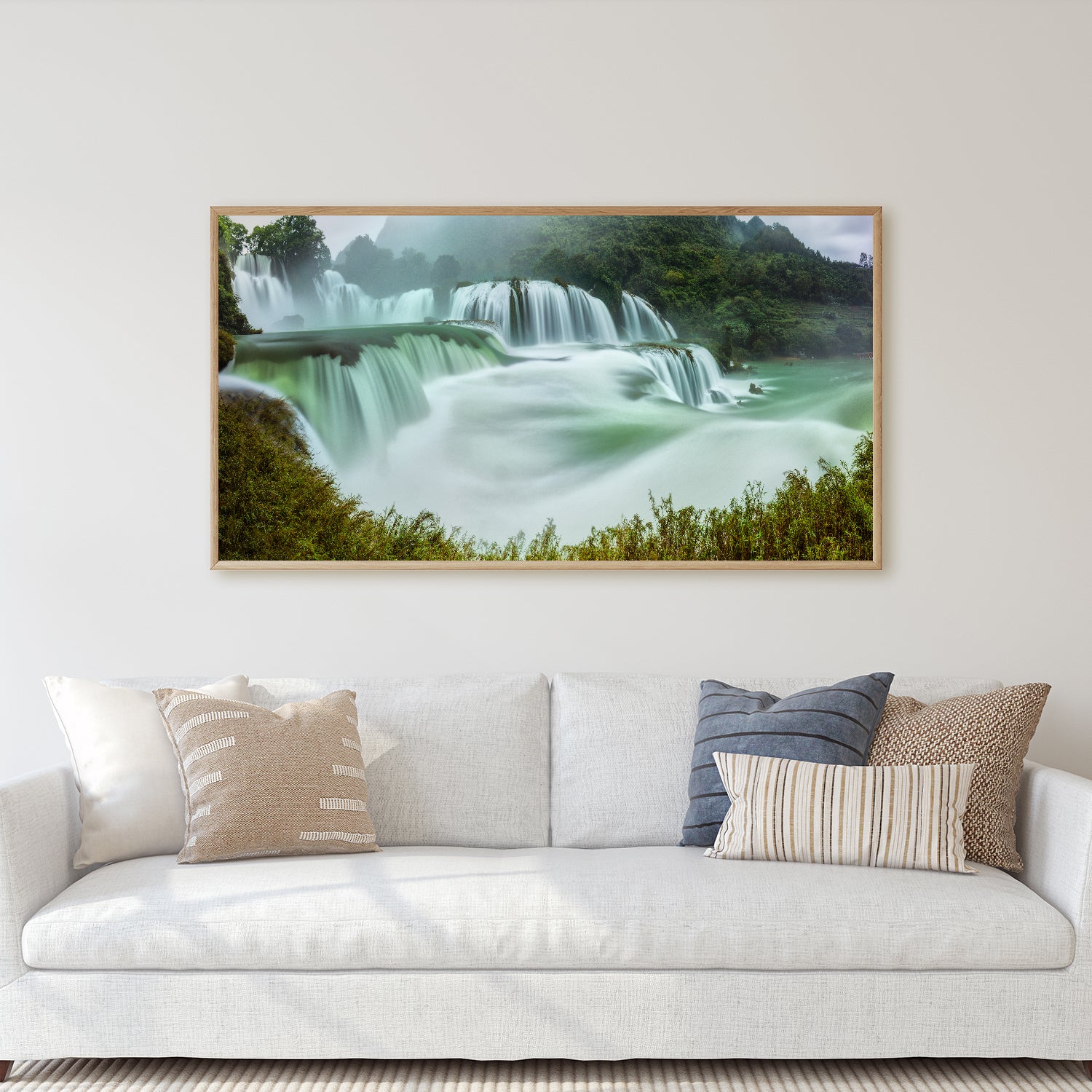 A painting of a majestic waterfall surrounded by lush greenery.